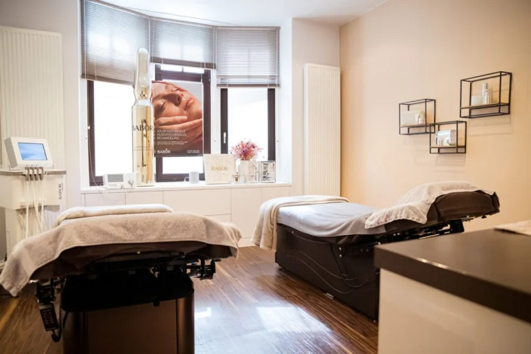 Duo treatment room with two treatment beds on a wooden floor in front of a bay window