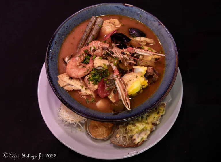 Bowl of fish stew with langoustine, prawn, razor clams and mussels, served with rouille and cheese toast