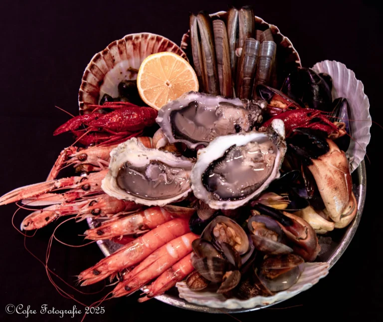 Seafood platter of oysters, langoustines, prawns, razor clams, mussels and crab claws with half a lemon