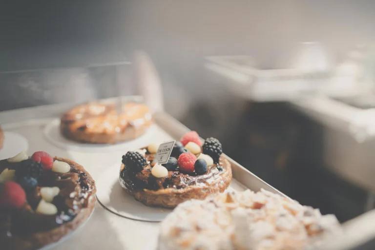 Fruit tartlets topped with berries on trays in the shop