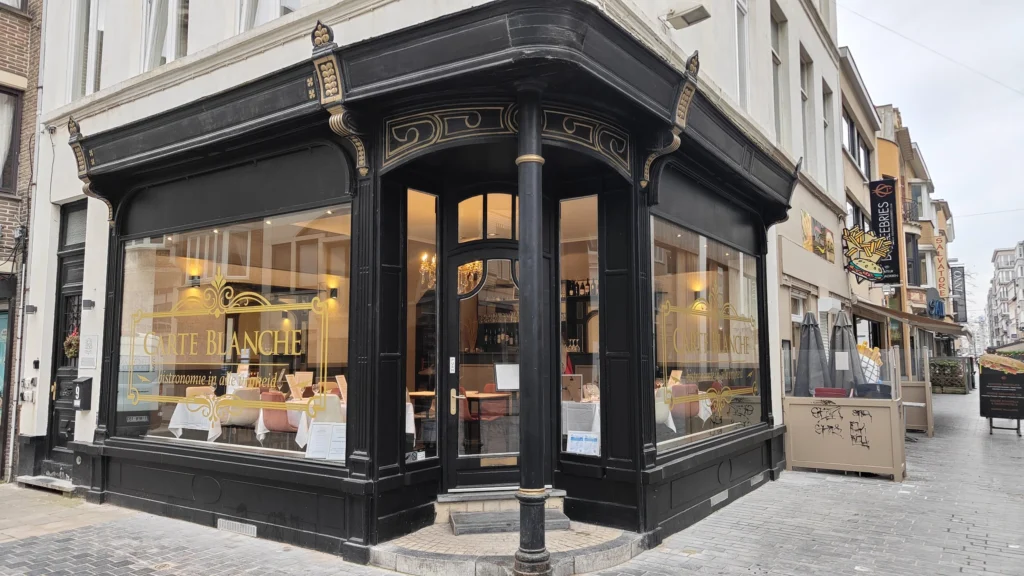 Carte Blanche's black corner frontage on Kerkstraat with gold lettering and large windows showing white-clothed tables inside