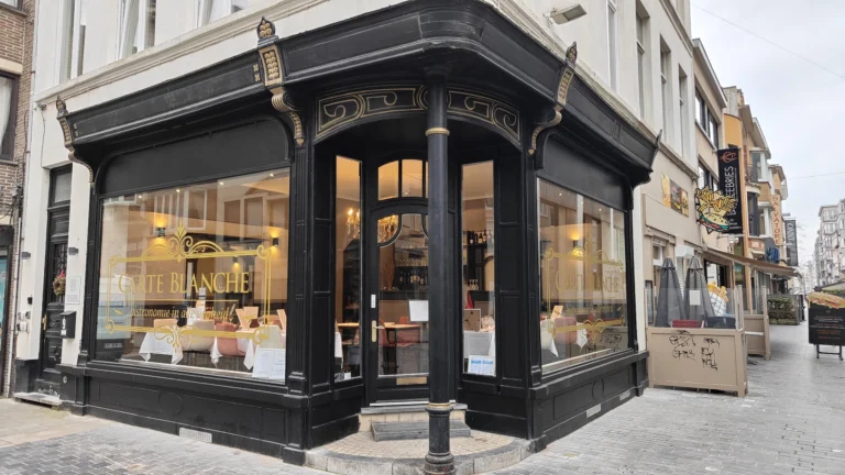 Carte Blanche's black corner frontage on Kerkstraat with gold lettering and large windows showing white-clothed tables inside