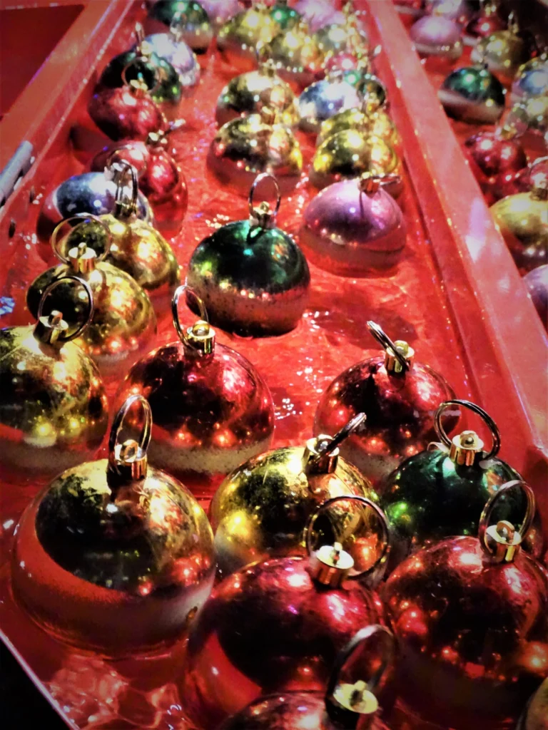Rows of shiny red, gold and green Christmas baubles on a stall at Ostend's Christmas market