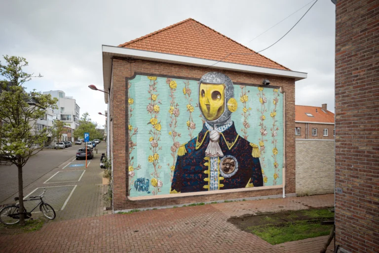Pixel Pancho mural of a robot in a naval uniform against floral wallpaper on a brick gable