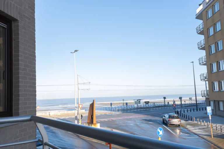 View from the apartment balcony across the seafront promenade to the beach and the sea