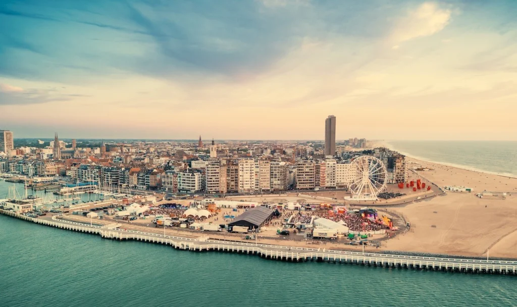 Aerial view of the festival site on the beach beside the harbour pier, with Ostend's skyline and Ferris wheel