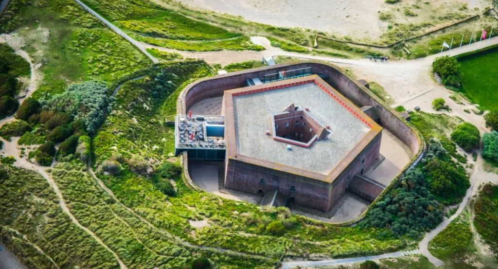 Aerial view of the pentagonal brick Fort Napoleon surrounded by green dunes and footpaths