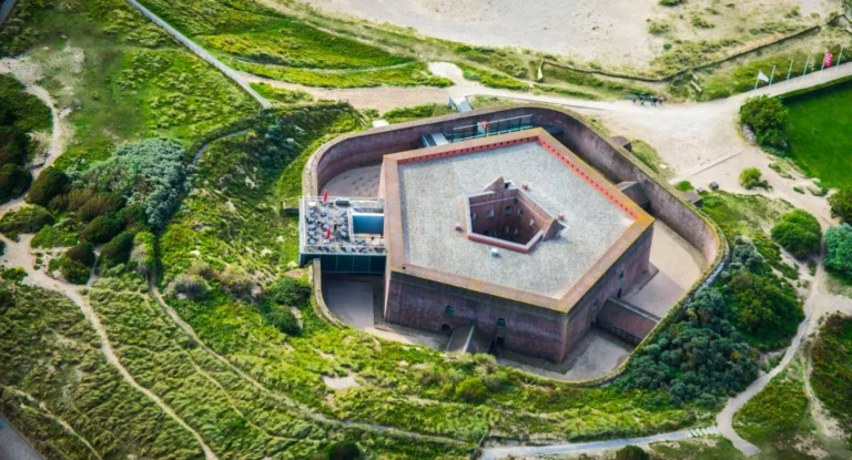 Aerial view of the pentagonal brick Fort Napoleon surrounded by green dunes and footpaths