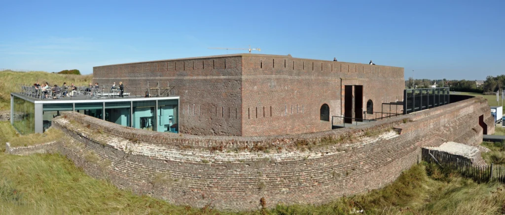 Fort Napoleon's curved brick walls in the Ostend dunes, with the glass brasserie pavilion and roof terrace