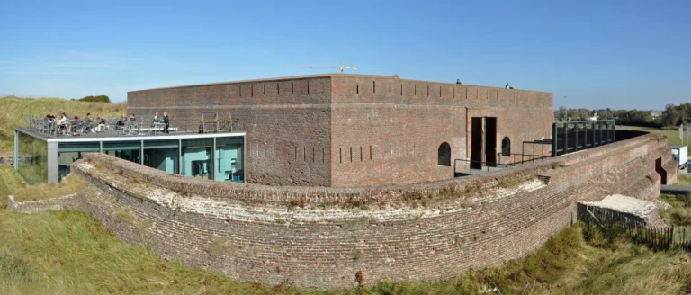 Fort Napoleon's curved brick walls in the Ostend dunes, with the glass brasserie pavilion and roof terrace