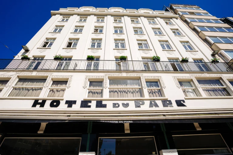 White Art Deco facade of Hotel Du Parc with its name in large black letters above the ground floor