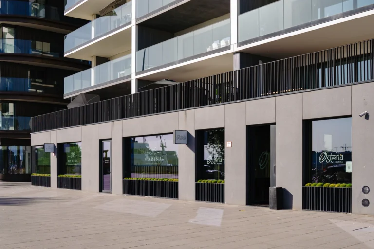 Ground-floor frontages of Marina and Osteria Marina beneath a modern apartment block