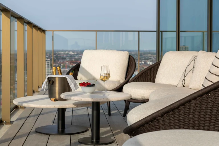 High-rise terrace with cushioned lounge chairs and views over the rooftops of Ostend