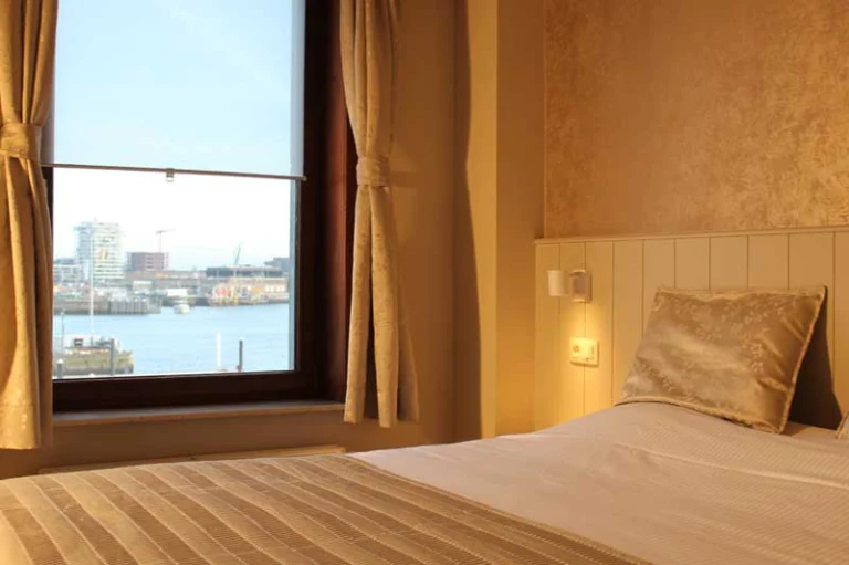 Simple hotel room with a double bed and a window looking out over the harbour water