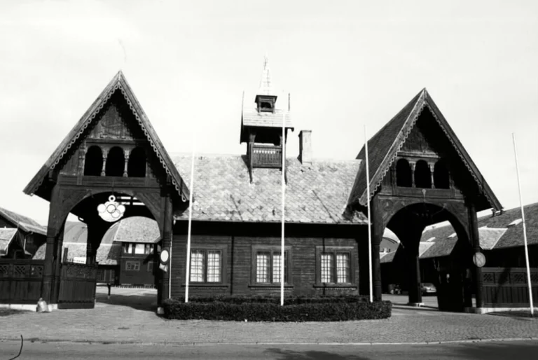 Black-and-white photo of the wooden gatehouse with its two gables, archways and small turret
