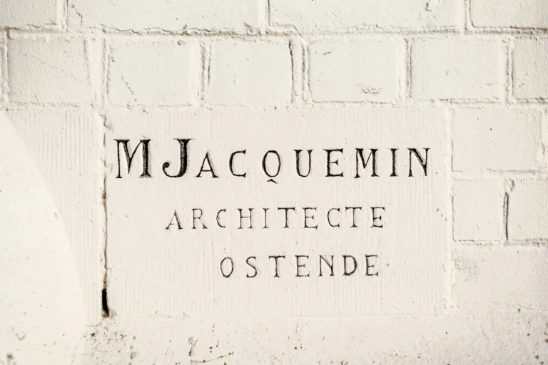 Whitewashed brick facade carved with the inscription ‘M Jacquemin Architecte Ostende’