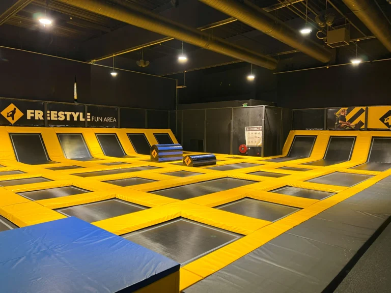 Freestyle area with rows of black trampolines, yellow padding and angled wall trampolines